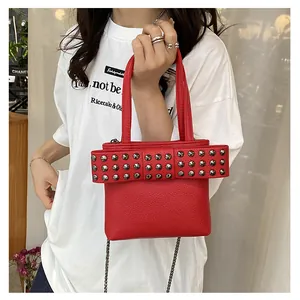 Sac bandoulière en cuir rouge avec grand nœud à rivets et fine bandoulière en chaîne