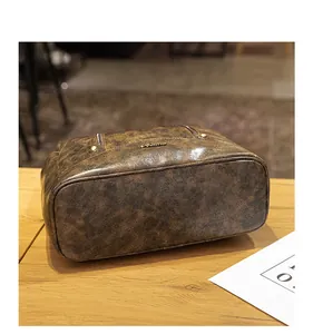 Λεπτομέρεια vintage καφέ σακιδίου με κόκκους δέρματος και μεταλλική πλάκα λογότυπου