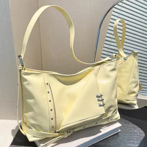 Sac fourre-tout jaune pâle style punk avec anneaux métalliques et détails zippés chic