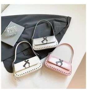 Detailed view of punk crossbody bags in silver, white, and pink with gothic cross buckle
