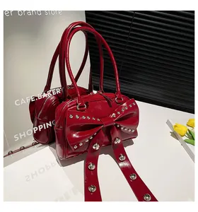 Detail of red patent leather handbag featuring a large bow with silver studs decoration