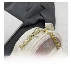 Détail du crochet métallique doré et de la fermeture éclair du sac rond blanc