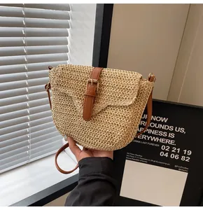 Detailopname van geweven strotuctuur met bruine leren riem en gouden gesp detail