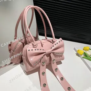 Pink patent leather bow shoulder bag with silver studs in a trendy Y2K aesthetic style
