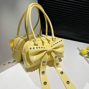 Pale yellow chic bow shoulder bag with silver rivet studs and glossy patent finish