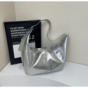 Detailed macro view of metallic silver tote bag texture with wide strap and zipper pocket