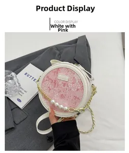 Détail du sac rond en cuir blanc et rose avec chaîne dorée et quatre grandes perles