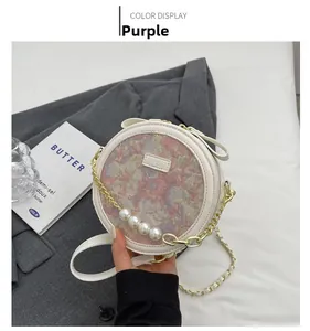Détail du sac rond jacquard violet avec chaîne dorée et accents de perles