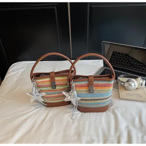 Dettaglio borsa a secchiello intrecciata con finiture in ecopelle e ciondolo stella