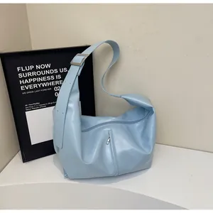 Detail of light blue hobo bag showing wide strap with silver buckle and vertical zipper