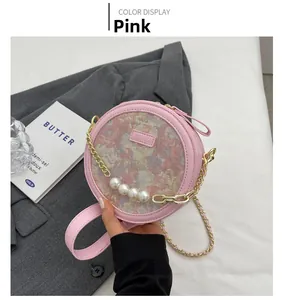 Détail d'un sac bandoulière rose rond avec tissu jacquard et détails de chaîne en perles