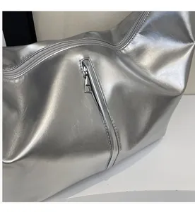 Detail shot of the smooth silver metal zipper on this high-gloss metallic tote bag