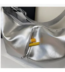 Detail of silver metallic hobo bag featuring a side zipper pocket for small accessories