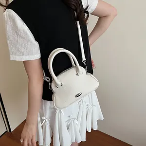 White lychee leather handbag for women featuring a unique shell shape and metal detail