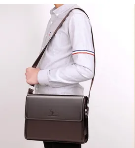 Detail of dark brown leather crossbody bag with kangaroo logo and adjustable strap