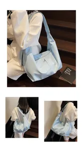 Detail view of glossy light blue patent leather hobo bag with wide shoulder strap