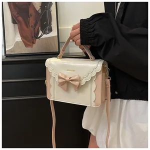 Detailed side view of sweet pink and white bow shoulder bag with wavy edge and gold buckle