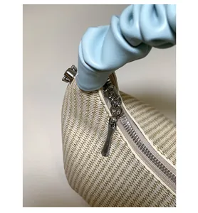 Dettaglio della trama intrecciata crema e manico a nuvola azzurro con cerniera argento