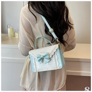 Detail of light blue bow and wavy edge design on a fashion crossbody bag for women