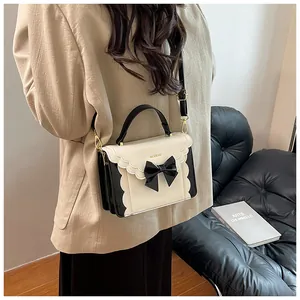 Model wearing a sweet bow-knot contrast color handbag with a wavy edge design