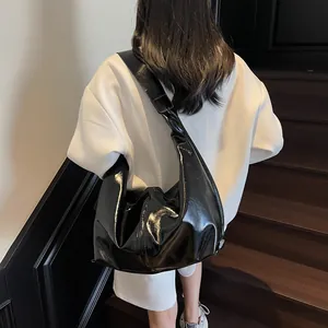 Fashionable black patent leather hobo bag for women with wide strap on model
