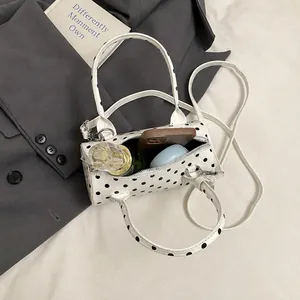 Detailed interior view of a polka dot cylinder handbag showing spacious storage capacity