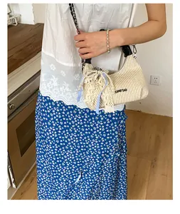 Dettaglio borsa a spalla in paglia beige con perle, fiocco in pizzo e logo CIHO'ZAD