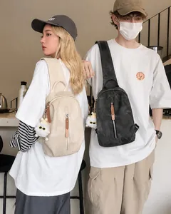 Detalle de los bolsos bandolera beige y gris con colgantes de peluche en los modelos