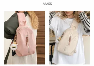 Detalle de bolsos bandolera de nailon rosa y beige con cremalleras largas y colgante de peluche
