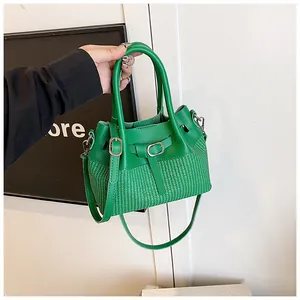 Vista detallada del bolso saco verde esmeralda con textura tejida y hebilla de metal