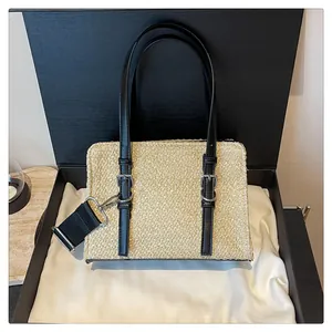 Detail of straw woven tote bag texture with black leather straps in elegant gift box