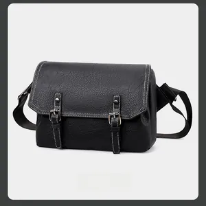 Close-up of black PU messenger bag with lychee texture and white contrast stitching