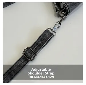 Close-up of adjustable shoulder strap with gunmetal hardware on grey denim tote bag