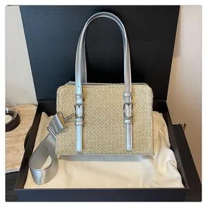Detailed view of beige woven tote bag with silver handles in a premium gift box setup