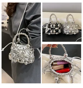 Dettaglio della mini borsa a secchiello con perline e chiusura con coulisse in argento