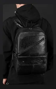 Detail of black textured leather backpack showing diagonal zippers and flap pocket
