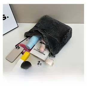Detailed interior of denim tote bag showing capacity for tablets, books and essentials