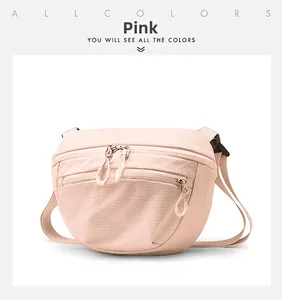 Close-up of light pink waterproof nylon crossbody bag with zipper details and buckles