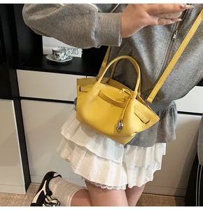 Close-up of bright yellow leather tote bag with lychee texture and silver pendant