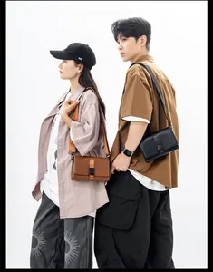 Detail of minimalist box crossbody bags in black and brown with buckle and nylon strap