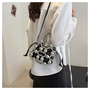 Dettaglio borsa a secchiello con perle argento e coulisse in pelle nera con sfere metalliche