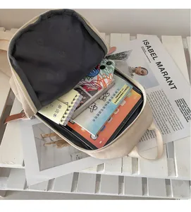 Vista interna dello zaino in tela beige con scomparti per laptop, tablet e accessori