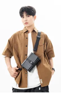 Close-up of minimalist black box crossbody bag featuring leather texture and nylon strap