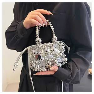 Dettaglio della borsa a secchiello con perle argento e chiusura a coulisse metallica