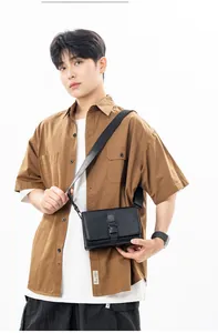 Close-up of a minimalist black box bag worn by a model in a brown shirt for casual styling