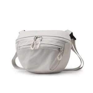 Waterproof grey nylon crossbody bag with adjustable strap and dual zippers for outdoor travel