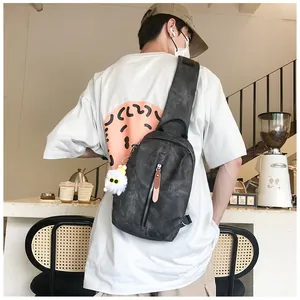 Borsa a tracolla uomo grigio antracite con texture vintage e ciondolo a sfera di peluche