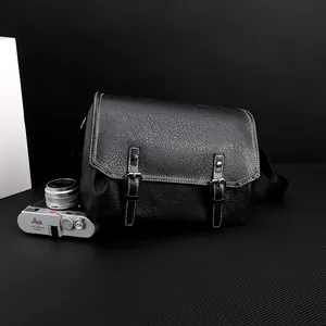 Detail of waterproof black PU leather messenger bag with white stitching and buckles