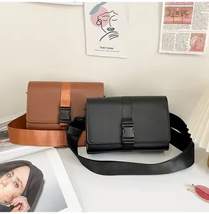 Detail of crossbody box bags in brown and black with wide nylon straps and buckle