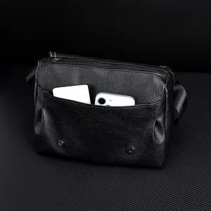 Detail of black PU leather messenger bag interior showing phone and power bank storage